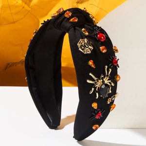 Detail of black knotted headband featuring golden spiders and red gemstones for Halloween