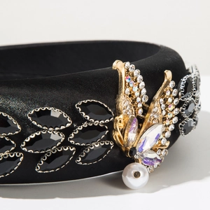 Close-up of black satin headband featuring a golden butterfly with sparkling rhinestones
