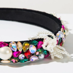 Detail of baroque velvet headband with colorful gemstones and pearl beaded bow