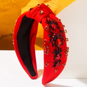 Detail of red knotted headband with 3D black spider and sparkling rhinestones
