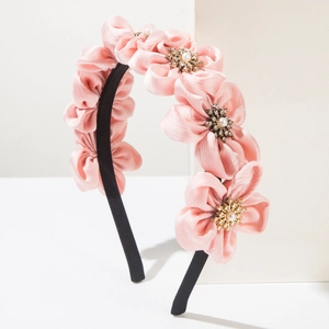 Detail of pink satin flower headband with sparkling rhinestones and pearl centerpieces