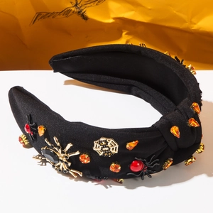 Detail of Halloween wide knotted headband with gold spider and orange rhinestone accents