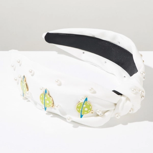 Detail of white knotted headband featuring imitation pearls and green enamel planet charms