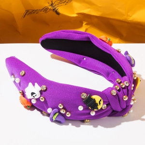 Detailed close-up of knotted Halloween headband with rhinestones, pearls, and spooky charms