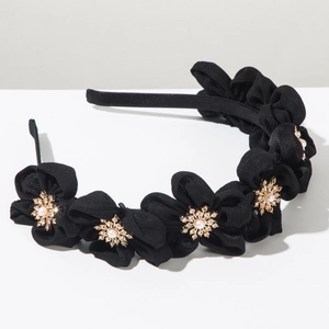 Close-up of black fabric floral headband with golden snowflake pearl and rhinestone detail