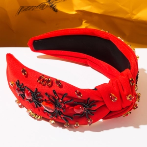 Detail of red knotted headband with black spiders and sparkling red rhinestones