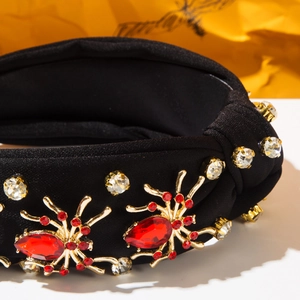 Macro shot of Halloween spider headband with red rhinestones on black fabric knot
