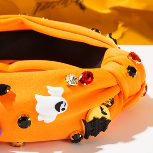 Detail of orange knotted Halloween headband featuring ghost, castle and rhinestones