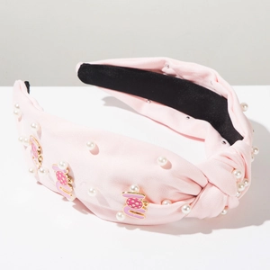 Pink knotted wide headband with white faux pearls and gold enamel charms detail