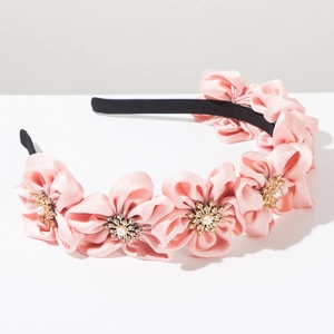 Detail of pink satin flowers with faux pearl centers on a stylish fashion headband