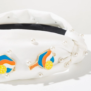 Detail of white wide knotted headband with pearls and pickleball enamel charms