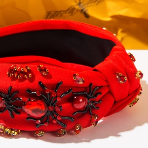 Detail of red rhinestone headband with a jeweled black spider for Halloween fashion
