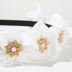 Detailed macro view of white organza flowers with pearl and crystal star center decorations