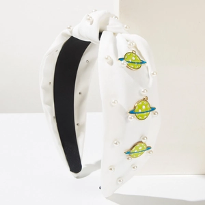 White knotted headband featuring faux pearls and colorful Saturn enamel charms