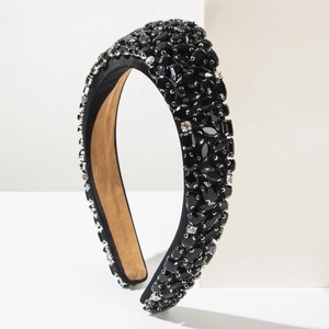 Detailed macro view of black crystal rhinestones hand-sewn on padded velvet headband