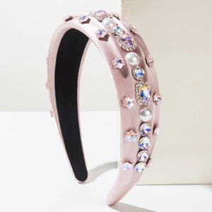 Detail of pink satin headband with white pearls and colorful crystals in retro style