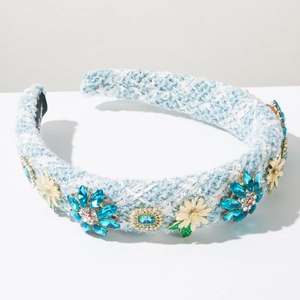 Détail du serre-tête en tweed bleu clair avec fleurs en cristal et décorations de marguerites