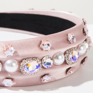 Detailed close-up of pink satin headband with pearls, star crystals and sparkling gemstones