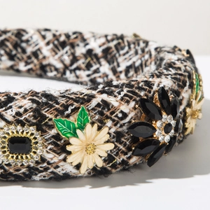 Détail d'un serre-tête en tweed avec marguerite émaillée et ornements en strass brillants