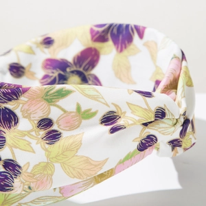 Dettaglio della fascia in tessuto intrecciato con stampe floreali viola e gialle
