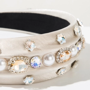 Detailed close-up of champagne satin headband with luxury pearls and crystal embellishments