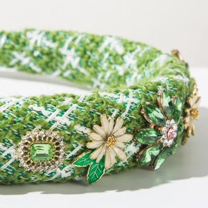 Gros plan sur le serre-tête en tweed vert avec fleurs en cristal et détails marguerites