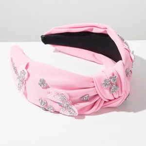 Detailed close-up of a pink knotted headband with sparkling silver rhinestone butterflies