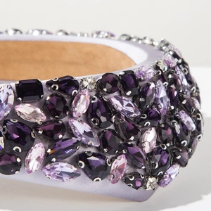 Macro detail of luxury baroque headband with purple crystals and satin fabric