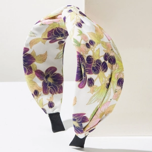 Cerchietto a nodo con fiori viola e foglie verdi su base in tessuto bianco