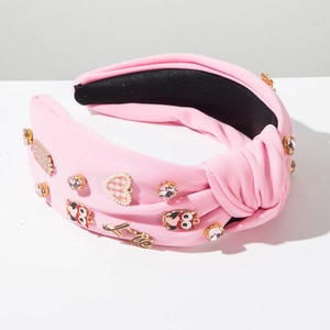 Detail of pink knotted headband featuring rhinestones, owls and golden LOVE letters