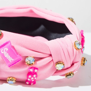 Vue détaillée d'un serre-tête rose avec strass et décorations de bonbons sucrés