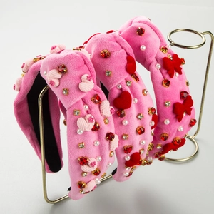 Détails des bandeaux en velours rose avec cœurs en strass et décorations de nœuds