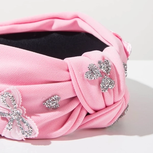 Detail of pink knotted headband with sparkling rhinestone butterfly and heart accents