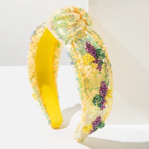 Detail of yellow sequined knot headband with colorful handmade beaded insect patterns