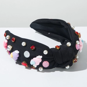 Detail of beaded headband with heart wings, faux pearls and red rhinestones