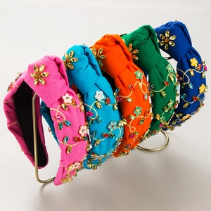 Detail of five knotted headbands with luxury colorful rhinestones and gold floral embroidery
