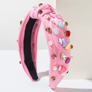 Detailed macro view of pink headband with pearls, rhinestones and winged heart accents