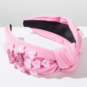 Detail view of pink knot headband with sparkling rhinestones and pearl-like heart accents