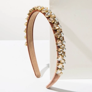 Detailed side view of velvet headband with golden heart crystals and white pearls