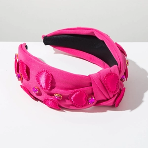 Detail of rose pink knotted headband featuring stitched hearts and sparkling crystals