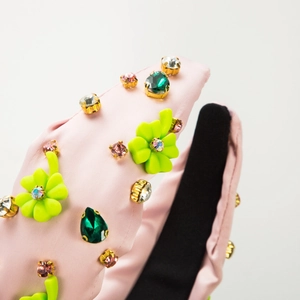Pink satin headband featuring colorful emerald-cut crystals and green floral accents