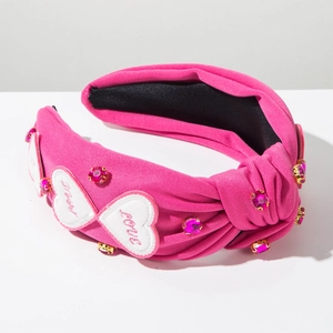 Détail d'un serre-tête noué rouge rose avec strass roses et écusson en cœur LOVE