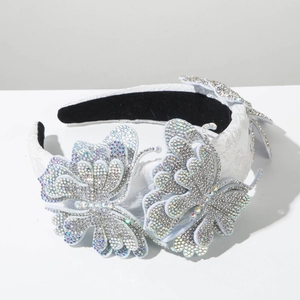Close-up of luxury white headband featuring dual butterflies with shimmering AB rhinestones