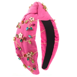 Detail of fuchsia headband with golden floral embroidery and colorful crystal rhinestones