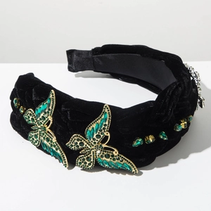 Détail du serre-tête en velours vintage avec ornements papillons en strass verts