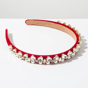 Detail of red velvet headband with rhinestones and pearls in golden metal claws