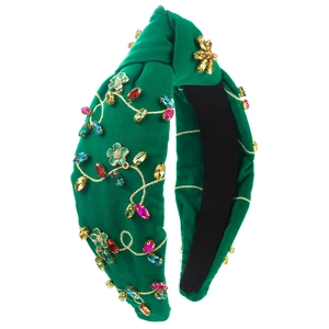 Detail of emerald green knotted headband with colorful rhinestones and floral embroidery