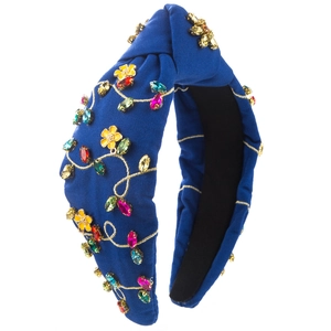 Detail of royal blue knotted headband with floral embroidery and colorful rhinestones