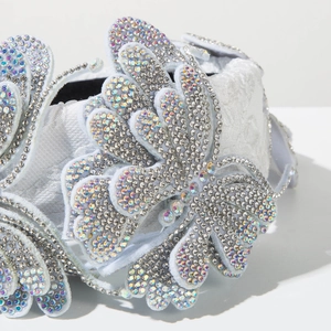 Detailed view of white lace headband with 3D crystal butterflies and iridescent rhinestones