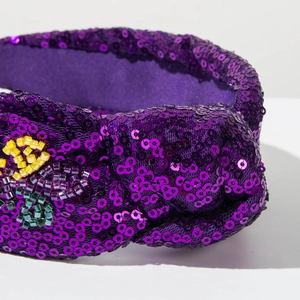 Detailed close-up of purple sequin headband with colorful bead floral embroidery